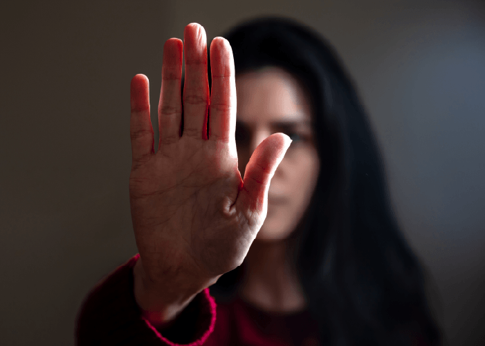mujer con la mano en alto en señal de parar